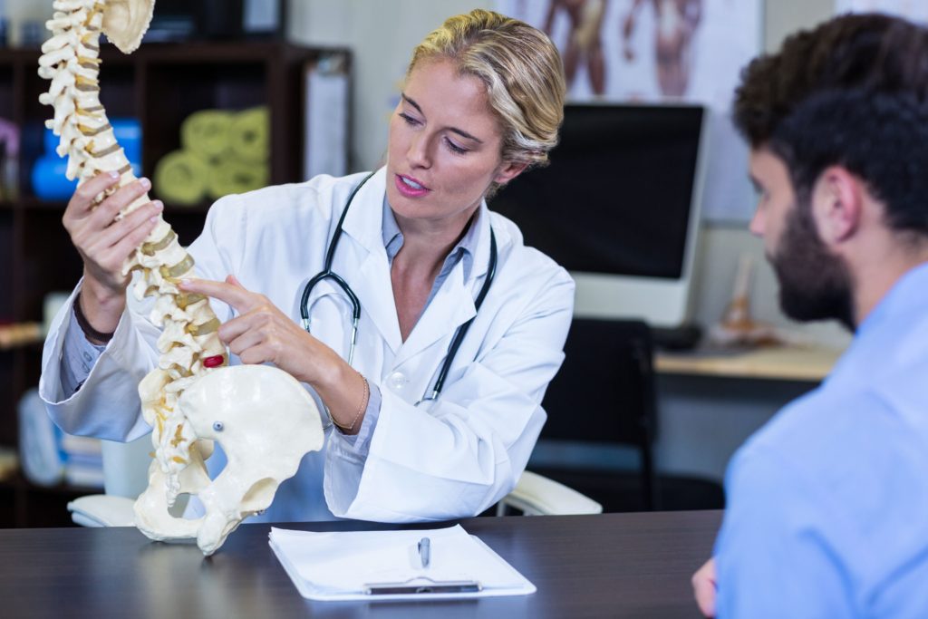 Online 12 Month Family Nurse Practitioner Programs - FNP doctor showing spine to man